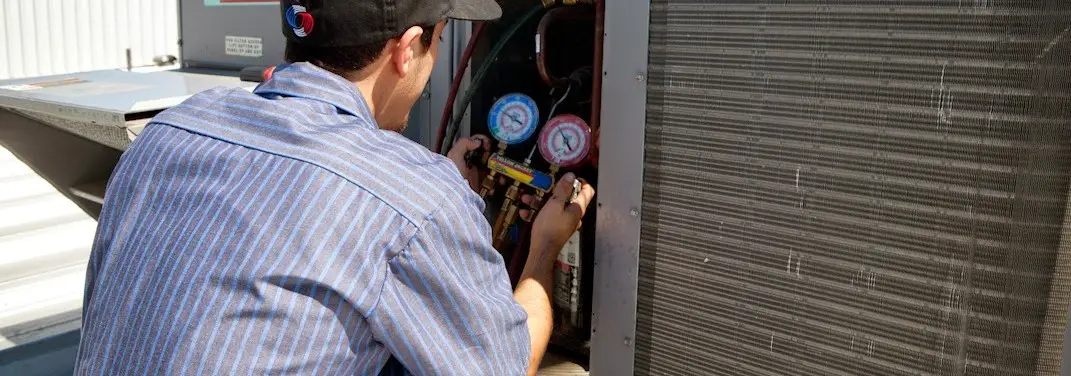 HVAC technician servicing a condenser unit in Washington