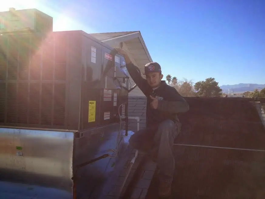 HVAC technician performing HVAC Inspection on a rooftop unit in Washington